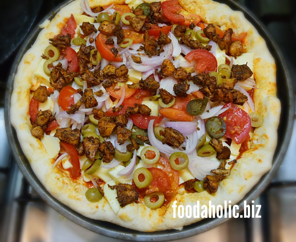Homemade Pizza Dough with toppings on a backing pan.